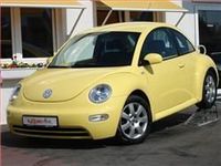 Stolzer Besitzer eines sonnengelben VW New Beetle